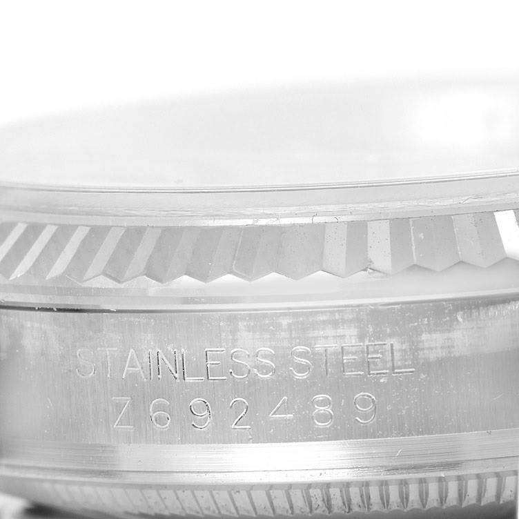 The image shows a close-up of the bezel and part of the casing of a Rolex Datejust 116234 Men's Stainless Steel Black Dial 116234 Men's Stainless Steel Black Dial model in stainless steel.