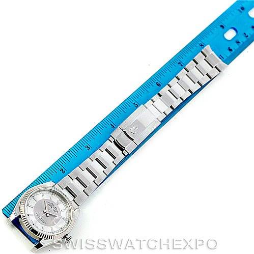 The Rolex Datejust 116234 Men's Stainless Steel Silver Dial 116234 Men's Stainless Steel Silver Dial watch is shown from a top-down angle alongside a blue ruler, displaying the entire band and face.