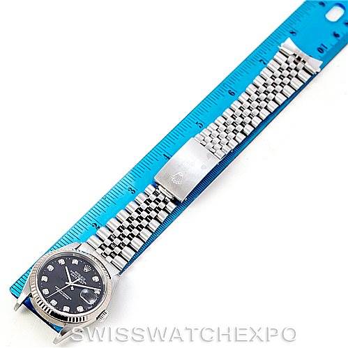The image shows a Rolex Datejust 16234 Men's Stainless Steel Black Dial 16234 Men's Stainless Steel Black Dial watch laid flat beside a blue ruler, highlighting its bracelet and clasp.