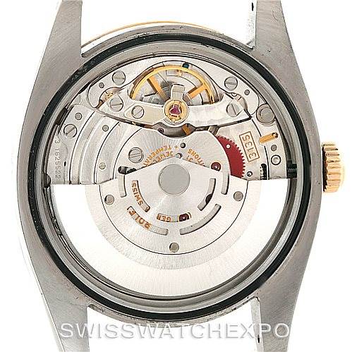 The image shows the back view of a Rolex Datejust 116233 Men
s Stainless Steel Champagne Dial 116233 Men
s Stainless Steel Champagne Dial watch, highlighting its inner mechanical movement.