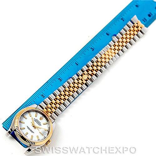 The image shows a Rolex Datejust 116233 Men
s Stainless Steel White Dial 116233 Men
s Stainless Steel White Dial watch laid flat against a blue measuring ruler, showing the full watch face and band.