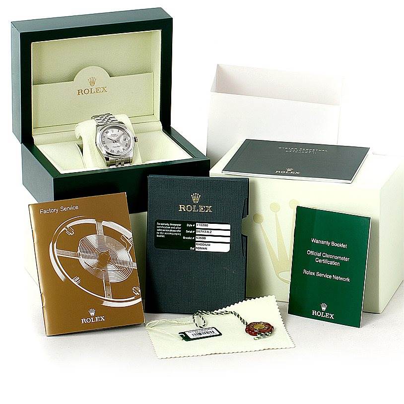The image shows a Rolex Datejust 116200 Men
s Stainless Steel Grey Dial 116200 Men
s Stainless Steel Grey Dial watch at a front angle, along with its box, certification booklets, and accessories.