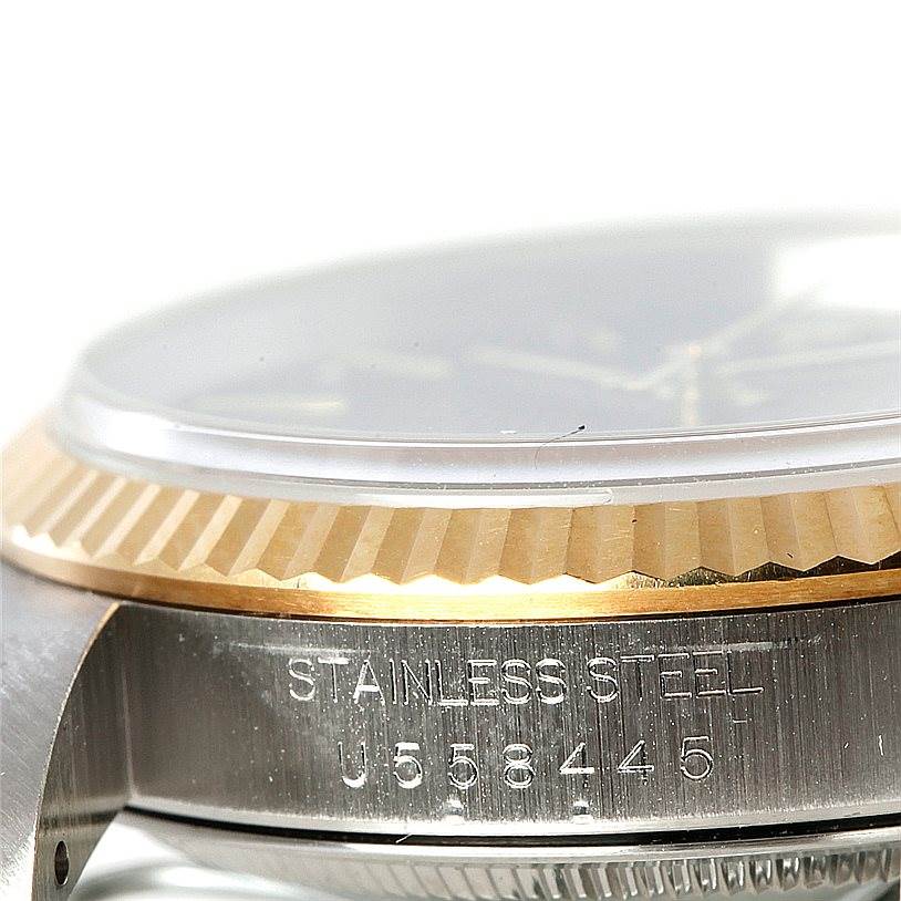 This close-up image of a Rolex Datejust 16233 Men's Steel and Gold (two tone) Black Dial 16233 Men's Steel and Gold (two tone) Black Dial watch showcases the side profile, bezel, and part of the case with the serial number.