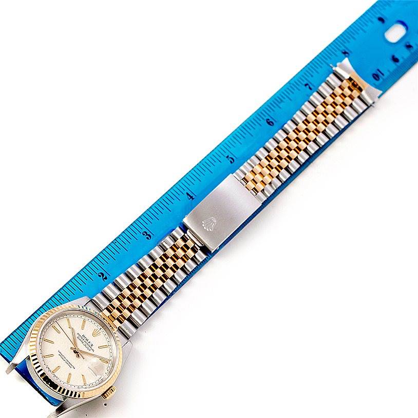 The image shows a Rolex Datejust 16233 Men's Steel and Gold (two tone) Beige Dial 16233 Men's Steel and Gold (two tone) Beige Dial watch laid flat with its bracelet and clasp alongside a blue ruler for measuring.