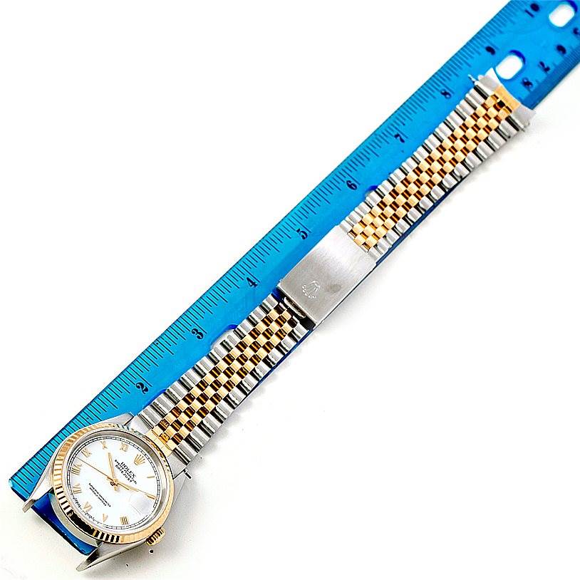 The Rolex Datejust 16233 Men's Steel and Gold (two tone) White Dial 16233 Men's Steel and Gold (two tone) White Dial watch is shown from a top view, featuring its face, bezel, and full bracelet with a ruler for scale.