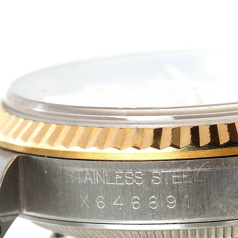 The image shows a close-up of the side of a Rolex Datejust 16233 Men's Steel and Gold (two tone) Champagne Dial 16233 Men's Steel and Gold (two tone) Champagne Dial watch, highlighting the stainless steel bezel and serial number.
