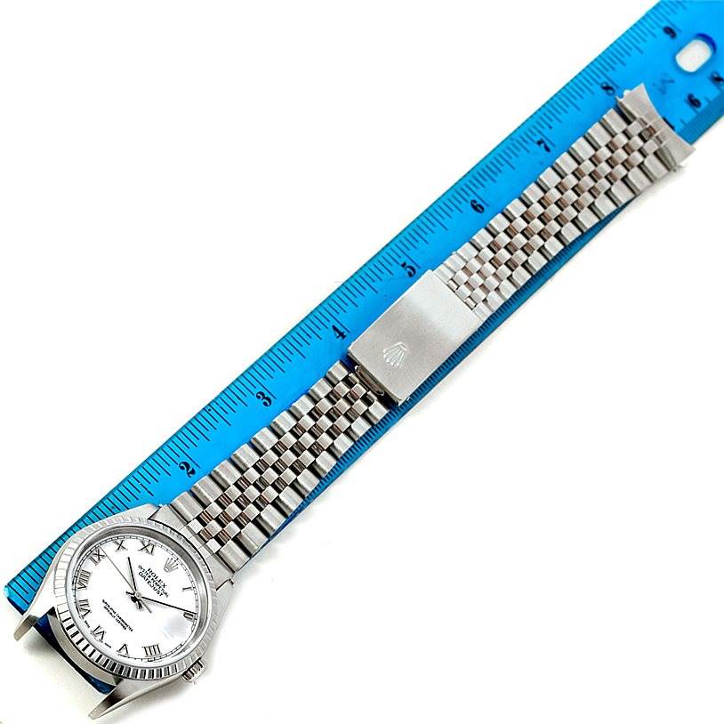 The image shows a Rolex Datejust 16220 Men's Stainless Steel White Dial 16220 Men's Stainless Steel White Dial watch laid flat next to a blue ruler, displaying its face, bezel, and full bracelet.