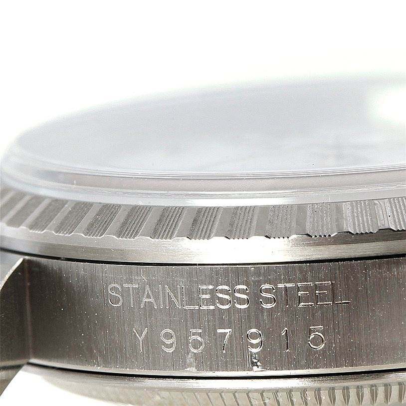 The image shows a close-up of the stainless steel case of a Rolex Datejust 16220 Men's Stainless Steel White Dial 16220 Men's Stainless Steel White Dial, highlighting the bezel and serial number.