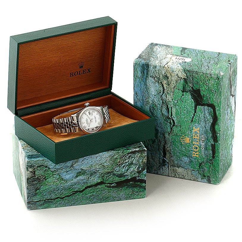 The Rolex Datejust 16220 Men's Stainless Steel White Dial 16220 Men's Stainless Steel White Dial watch is shown in its open green and wood-tone box, with another green marbled box beside it.