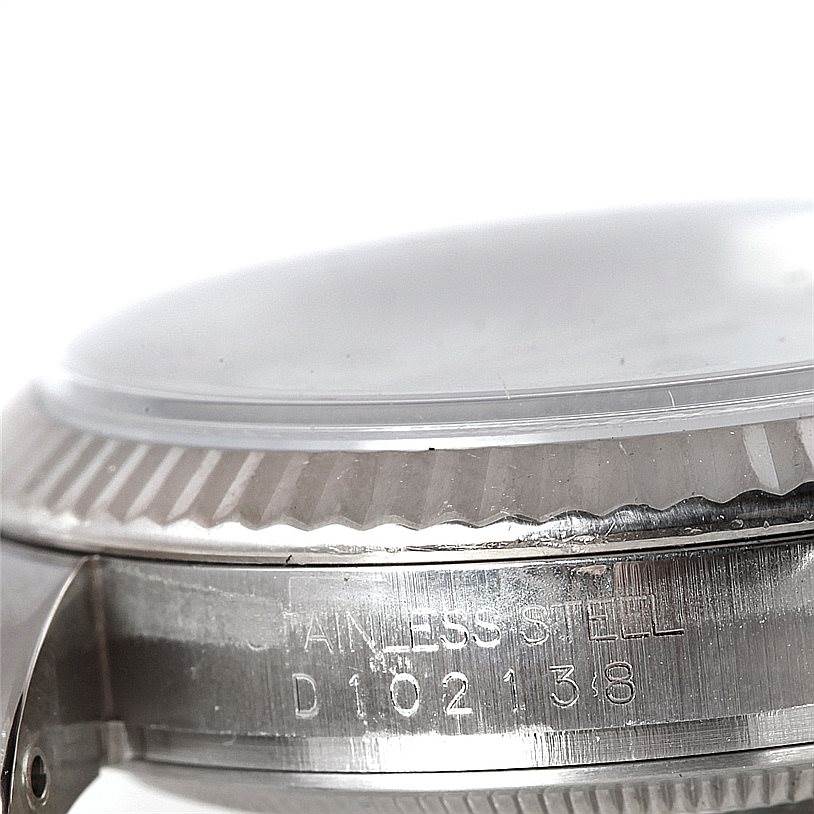 The close-up image shows the side view of the bezel and casing of the Rolex Datejust 116234 Men
s Stainless Steel White Dial 116234 Men
s Stainless Steel White Dial watch, made of stainless steel with engraved serial numbers.