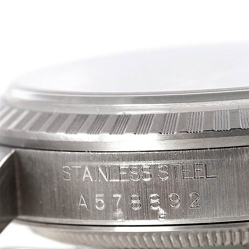 This image shows a close-up of the side of a Rolex Datejust 16220 Men
s Stainless Steel Black Dial 16220 Men
s Stainless Steel Black Dial watch, highlighting its stainless steel material and serial number.