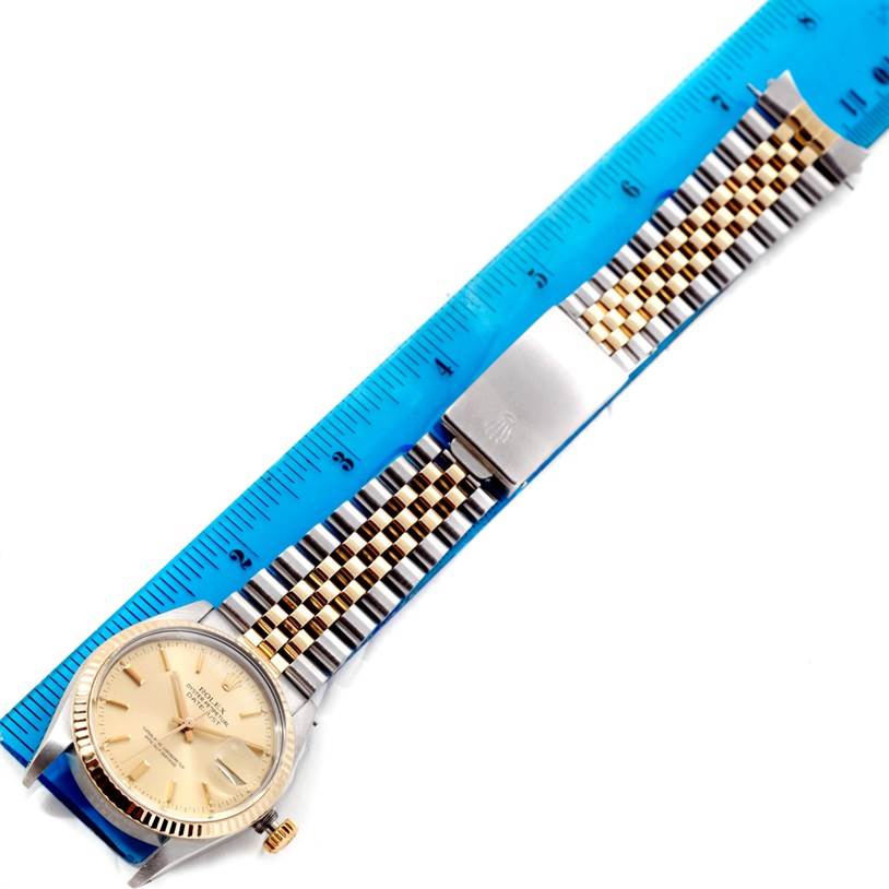 The image shows a Rolex Datejust 16013 Men's Stainless Steel Champagne Dial 16013 Men's Stainless Steel Champagne Dial watch placed flat, revealing the face, bezel, and two-tone bracelet beside a ruler.