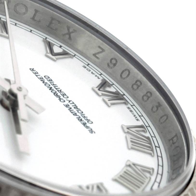 This close-up angle of the Rolex Datejust 116234 Men
s Stainless Steel White Dial 116234 Men
s Stainless Steel White Dial model showcases a partial view of the dial, hands, and the rehaut with engraved serial number and logo.