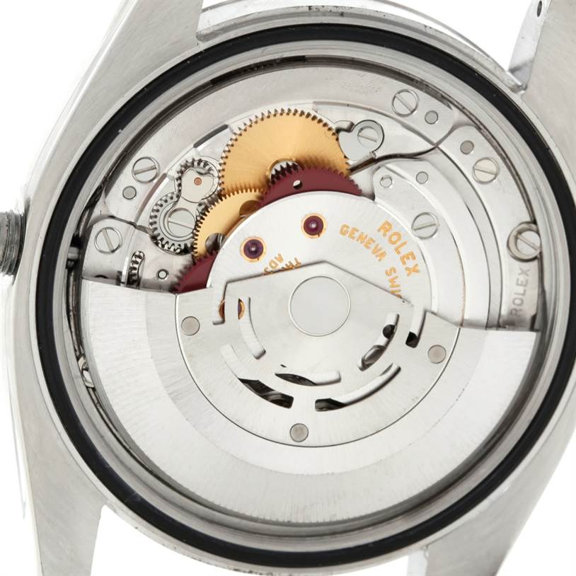 The image shows the internal mechanism of a Rolex Datejust 116234 Men
s Stainless Steel White Dial 116234 Men
s Stainless Steel White Dial watch with gears and movement components.