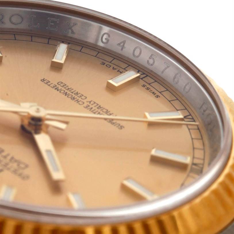 The image shows a close-up of the Rolex Datejust 116233 Men
s Stainless Steel Champagne Dial 116233 Men
s Stainless Steel Champagne Dial model, focusing on the bezel and part of the dial with the serial number.