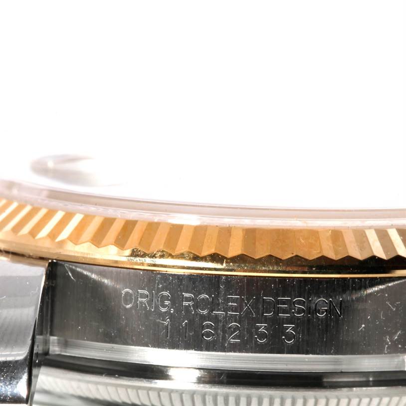 The image shows a close-up of the side of a Rolex Datejust 116233 Men
s Stainless Steel Champagne Dial 116233 Men
s Stainless Steel Champagne Dial watch, focusing on the bezel and the serial number.