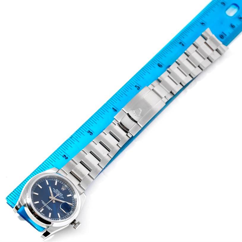 This image shows a top-down view of a Rolex Datejust 116200 Men's Stainless Steel Blue Dial 116200 Men's Stainless Steel Blue Dial watch with a blue dial, alongside a ruler for scale.