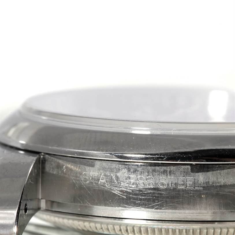 The image shows a close-up side angle of a stainless steel case and bezel for a Rolex Datejust 116200 Men's Stainless Steel Blue Dial 116200 Men's Stainless Steel Blue Dial watch.