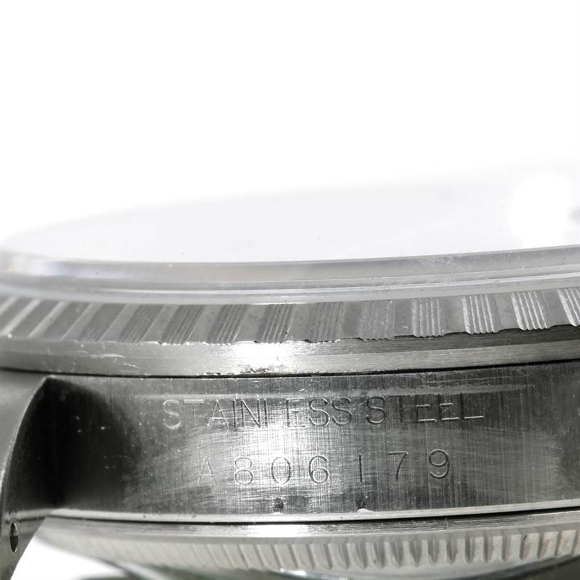 This image shows a close-up side view of a Rolex Datejust 16220 Men's Stainless Steel Blue Dial 16220 Men's Stainless Steel Blue Dial watch bezel and case, highlighting the stainless steel and serial number.