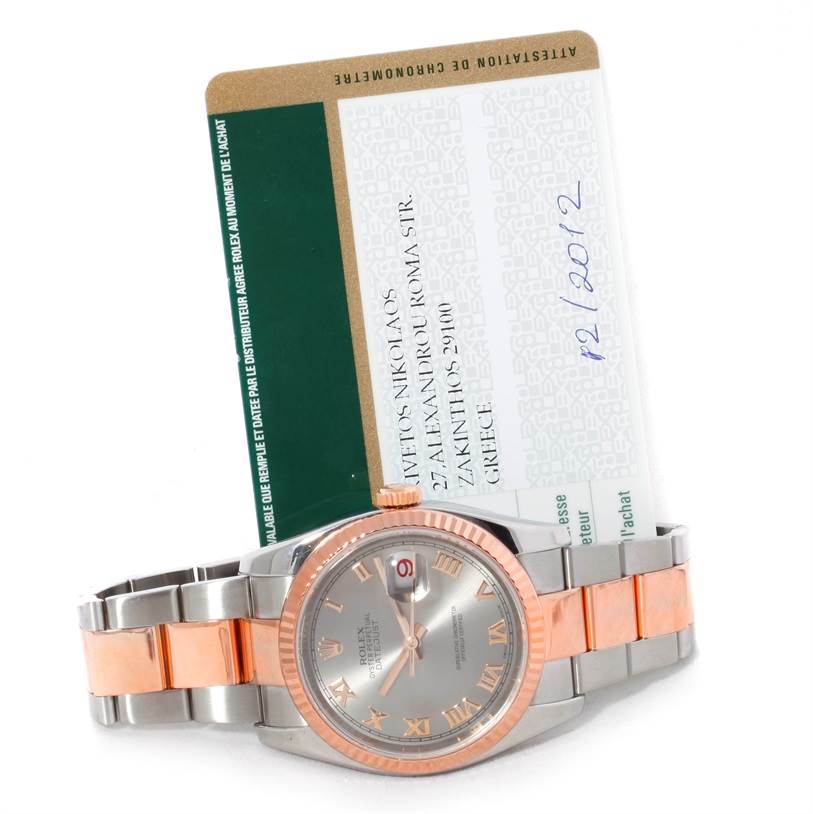 The Rolex Datejust 116231 Men's Steel and Gold (two tone) Pink Dial 116231 Men's Steel and Gold (two tone) Pink Dial watch is displayed from a slight angle, showing the face, bezel, and part of the bracelet, with a certification card behind it.