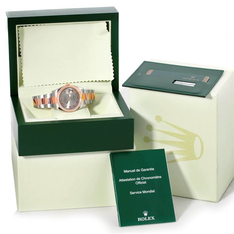 The Rolex Datejust 116231 Men's Steel and Gold (two tone) Pink Dial 116231 Men's Steel and Gold (two tone) Pink Dial watch is shown in an open box, along with its warranty cards and user manuals.