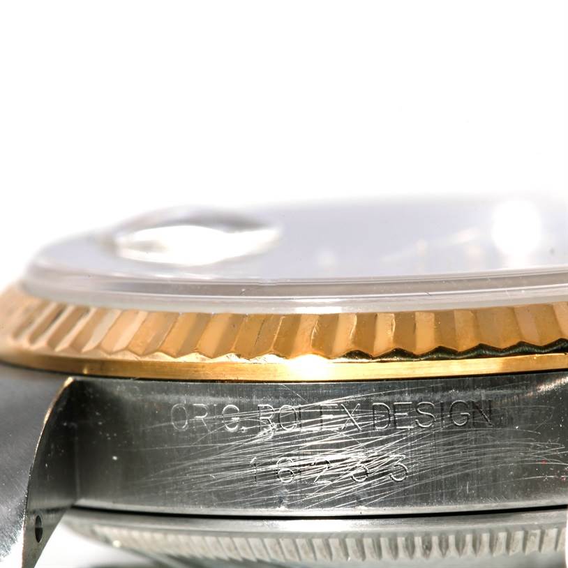 This image shows a close-up side view of the case and bezel of a Rolex Datejust 16233 Men's Steel and Gold (two tone) Champagne Dial 16233 Men's Steel and Gold (two tone) Champagne Dial watch, highlighting its gold fluted bezel and engraved case design.