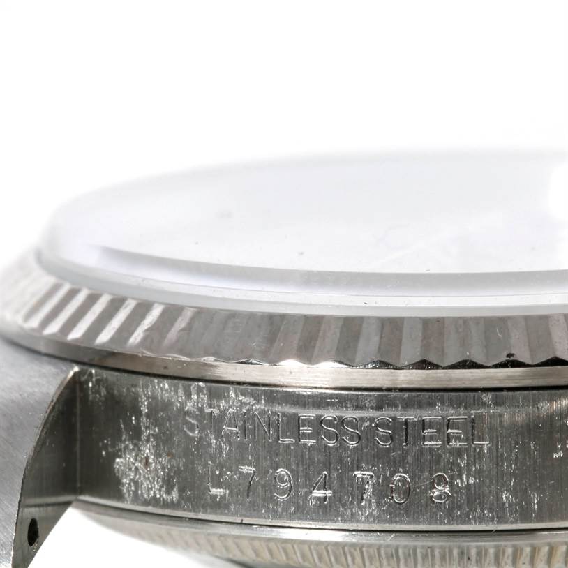 The image shows a close-up of the side of a Rolex Datejust 16234 Men's Stainless Steel Silver Dial 16234 Men's Stainless Steel Silver Dial watch, highlighting the serial number and stainless steel material.