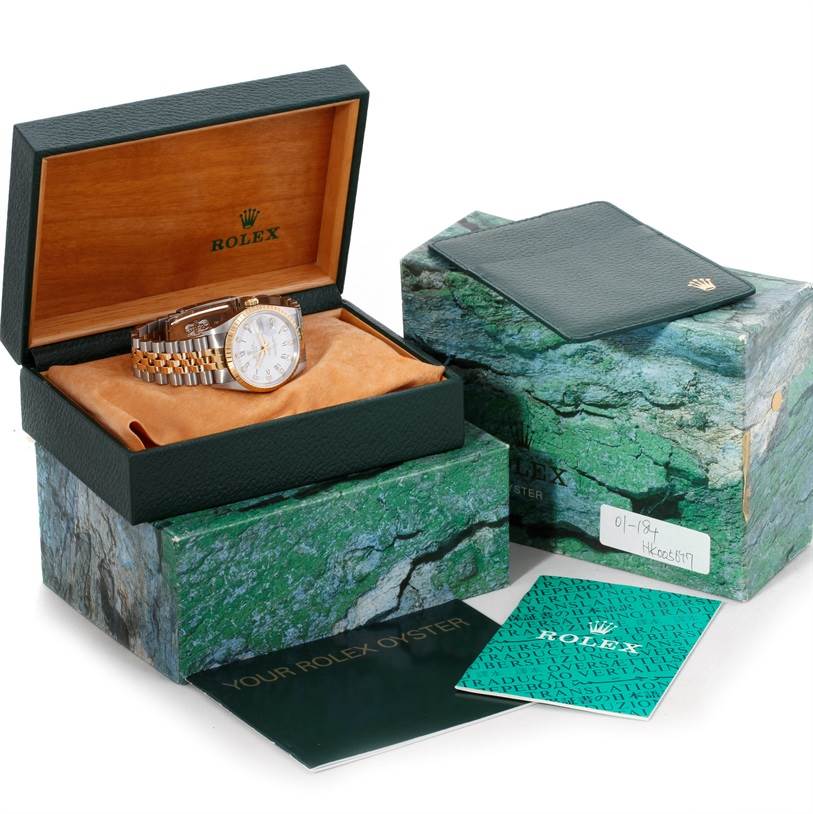 The Rolex Datejust 15223 Men's Steel and Gold (two tone) White Dial 15223 Men's Steel and Gold (two tone) White Dial watch is shown inside an open box with additional accessory boxes and booklets beside it.