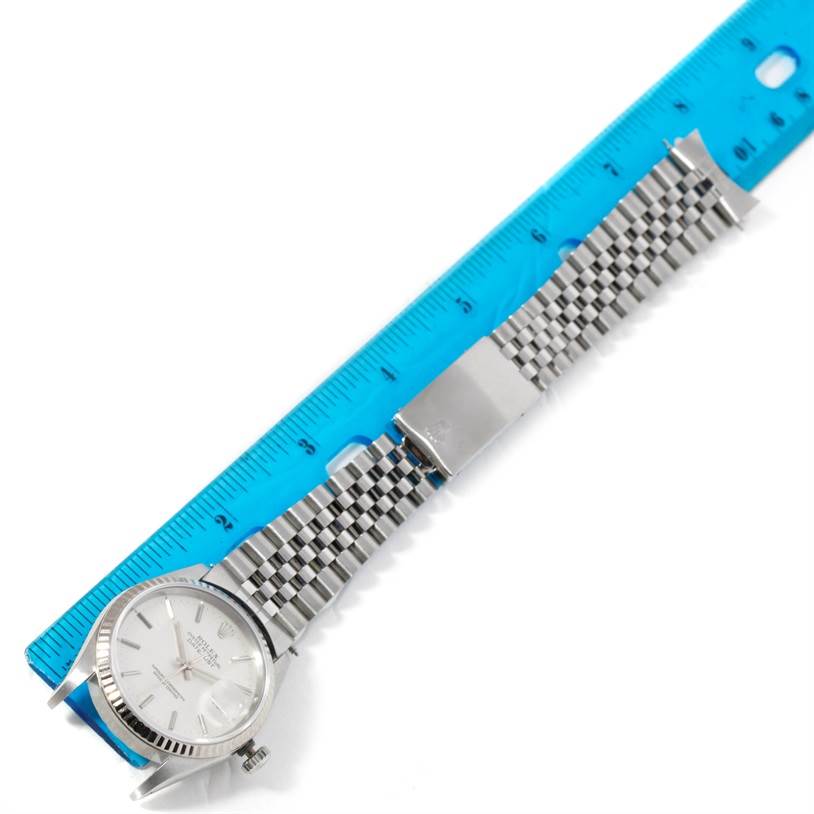 The image shows a Rolex Datejust 16234 Men's Stainless Steel Silver Dial 16234 Men's Stainless Steel Silver Dial watch laid flat next to a blue ruler, showcasing the face and metal bracelet.