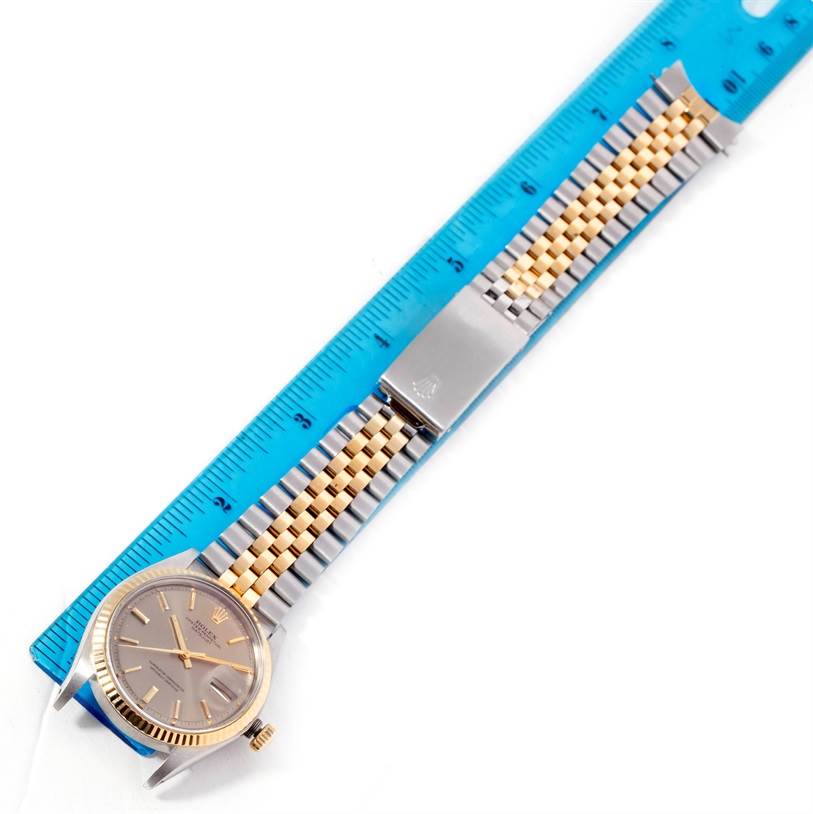 The image shows a Rolex Datejust 1601 Men's Stainless Steel Brown Dial 1601 Men's Stainless Steel Brown Dial watch laid flat, with a blue ruler measuring its two-tone bracelet.