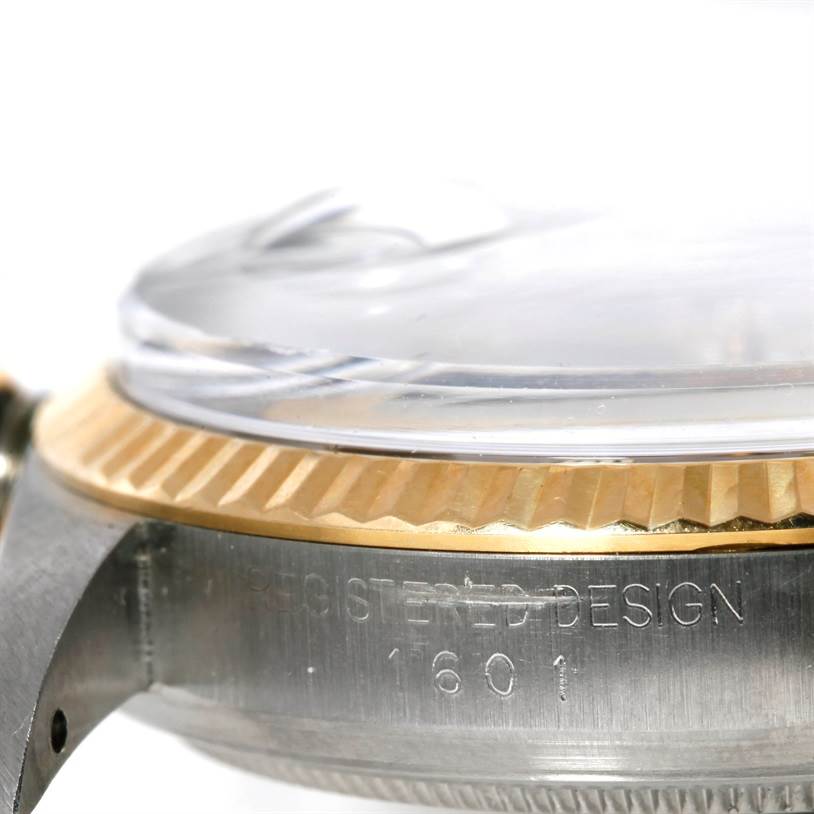 The image shows a close-up side view of a Rolex Datejust 1601 Men's Stainless Steel Brown Dial 1601 Men's Stainless Steel Brown Dial watch, highlighting its bezel and part of the casing with engraved details.