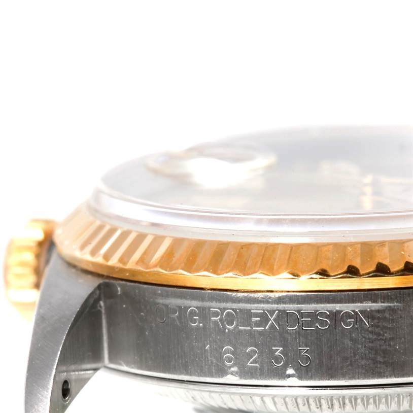 This image shows a close-up side view of a Rolex Datejust 16233 Men's Steel and Gold (two tone) Champagne Dial 16233 Men's Steel and Gold (two tone) Champagne Dial watch, highlighting the bezel, crystal, crown, and part of the case with engravings.