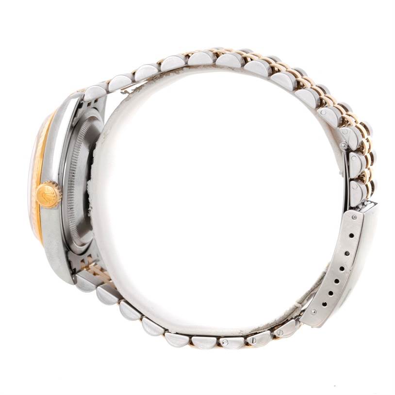 This side angle of a Rolex Datejust 16233 Men's Steel and Gold (two tone) Champagne Dial 16233 Men's Steel and Gold (two tone) Champagne Dial watch shows the band, crown, and a portion of the case.