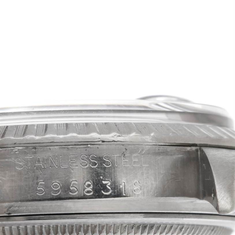 This image shows a close-up side view of a Rolex Datejust 16030 Men
s Stainless Steel Grey Dial 16030 Men
s Stainless Steel Grey Dial model, focusing on the bezel and engraved "STAINLESS STEEL" with serial numbers.
