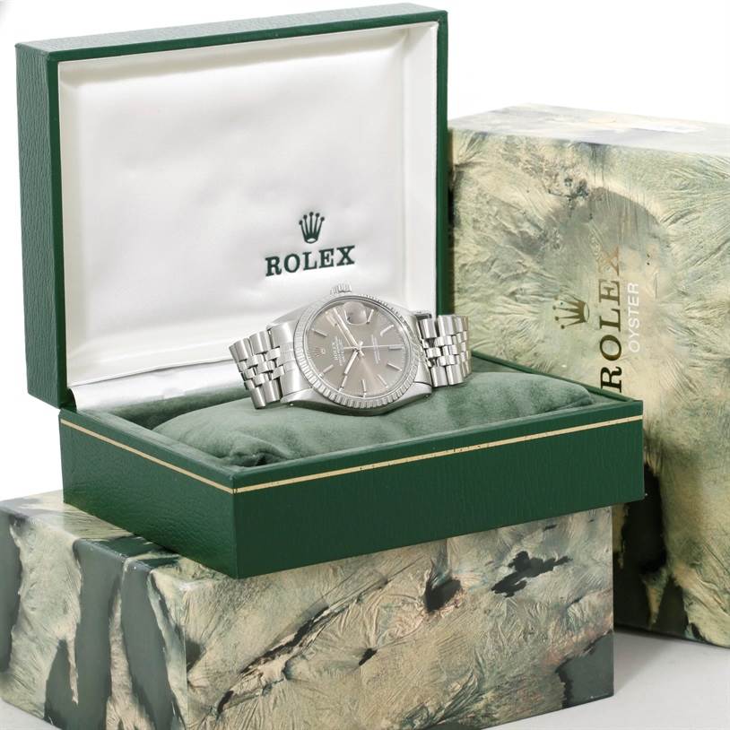 The Rolex Datejust 16030 Men
s Stainless Steel Grey Dial 16030 Men
s Stainless Steel Grey Dial watch is shown from the front, displayed in its green box with additional packaging in the background.