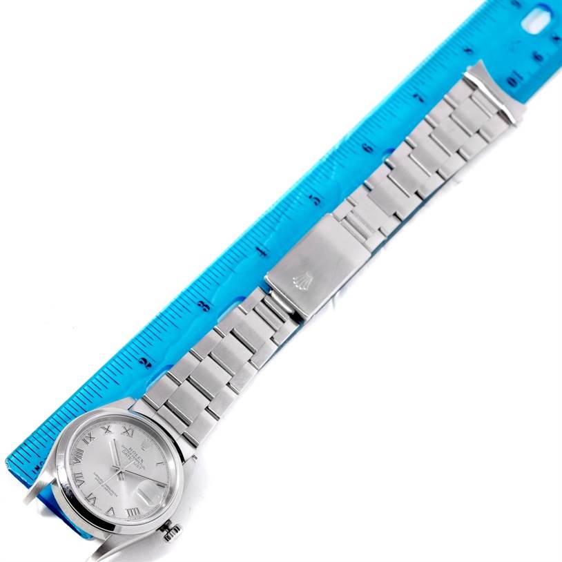 The Rolex Datejust 16200 Men's Stainless Steel Silver Dial 16200 Men's Stainless Steel Silver Dial watch is shown at a top-down angle, displaying the face, bracelet, and clasp next to a blue ruler for scale.