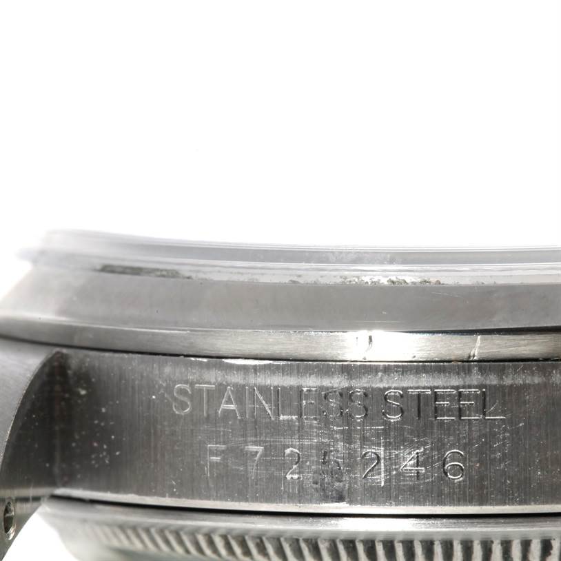 The image shows a close-up side view of a Rolex Datejust 16200 Men's Stainless Steel Silver Dial 16200 Men's Stainless Steel Silver Dial watch case, focusing on the stainless steel inscription and serial number.