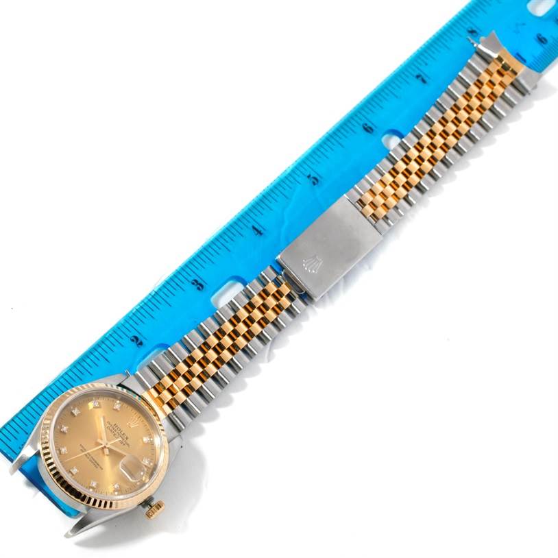 The Rolex Datejust 16233 Men
s Steel and Gold (two tone) Champagne Dial 16233 Men
s Steel and Gold (two tone) Champagne Dial watch is displayed from a top-down angle showing the face, crown, and entire two-tone bracelet.