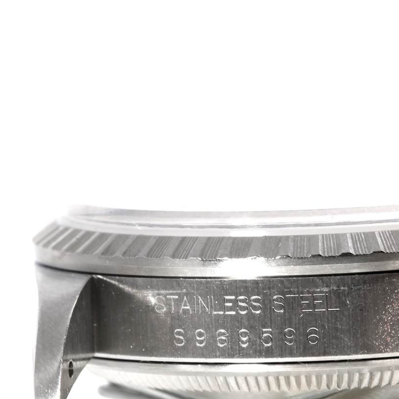 The image shows a close-up side view of the Rolex Datejust 16220 Men's Stainless Steel Silver Dial 16220 Men's Stainless Steel Silver Dial watch, focusing on the bezel and stainless steel serial number.