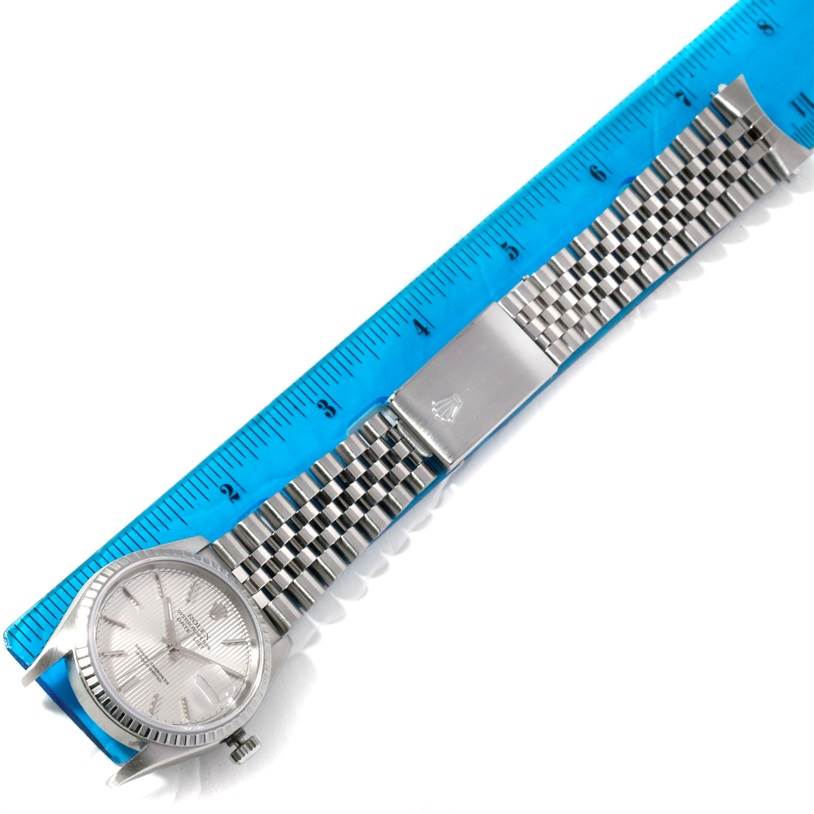 This image shows a Rolex Datejust 16220 Men's Stainless Steel Silver Dial 16220 Men's Stainless Steel Silver Dial watch laid flat with a ruler for scale, highlighting the watch face, band, and clasp.