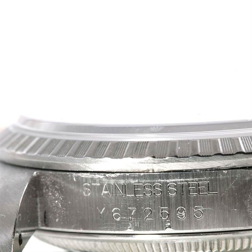 The image shows a close-up of the case side and fluted bezel of a Rolex Datejust 16220 Men's Stainless Steel Silver Dial 16220 Men's Stainless Steel Silver Dial, highlighting the stainless steel engraving.