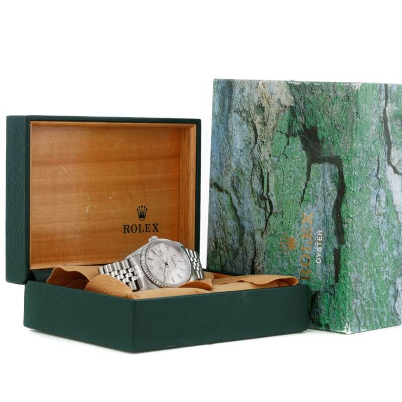 The Rolex Datejust 16220 Men's Stainless Steel Silver Dial 16220 Men's Stainless Steel Silver Dial watch is displayed in its green box at an angle showing the face and a portion of the band.