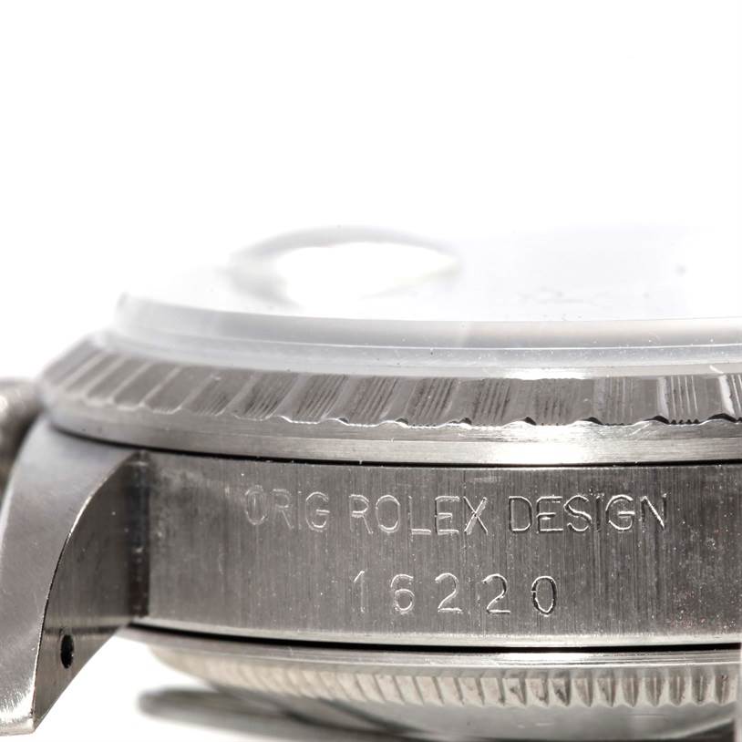 The image shows a close-up of the side of a Rolex Datejust 16220 Men
s Stainless Steel Grey Dial 16220 Men
s Stainless Steel Grey Dial watch, displaying the model number "16220" and "ORIG ROLEX DESIGN" engraving.