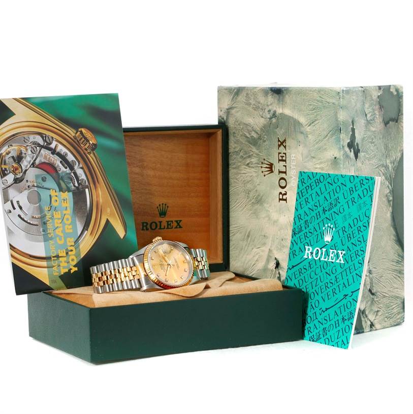 The image shows a Rolex Datejust 16233 Men's Steel and Gold (two tone) Champagne Dial 16233 Men's Steel and Gold (two tone) Champagne Dial watch in its open box, accompanied by manuals and outer packaging in an angled view.