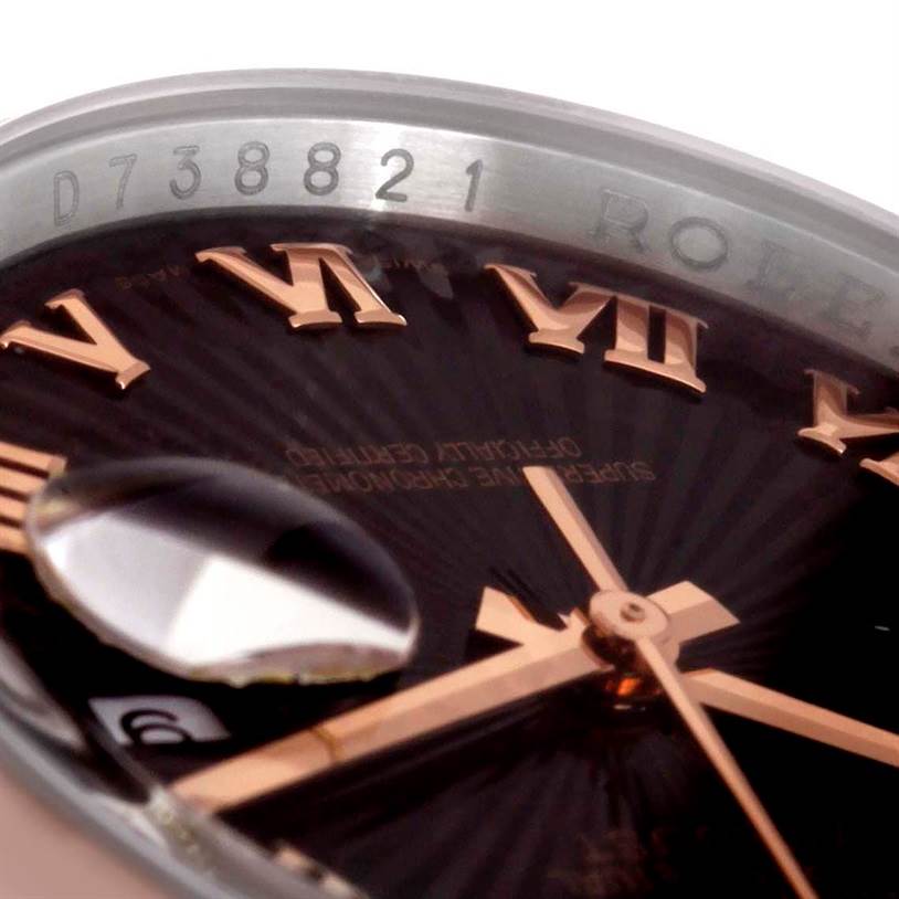 This close-up of a Rolex Datejust 116201 Men
s Steel and Gold (two tone) Black Dial 116201 Men
s Steel and Gold (two tone) Black Dial watch shows the serial number, Roman numeral markers, and magnified date window.