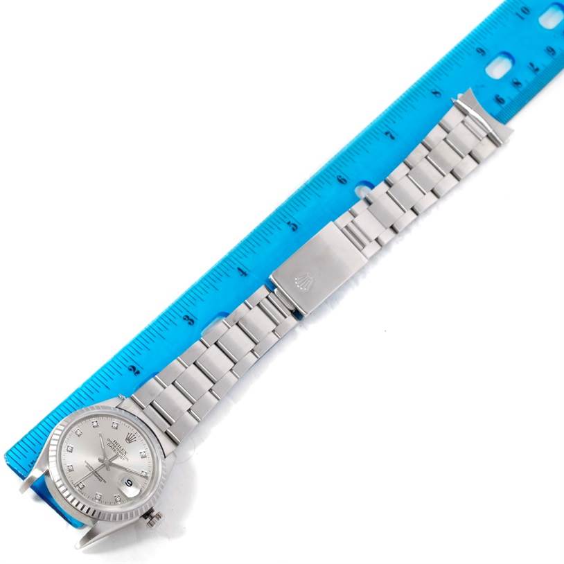 The image shows the Rolex Datejust 16220 Men's Stainless Steel Silver Dial 16220 Men's Stainless Steel Silver Dial watch laid flat with its bracelet extended, next to a blue ruler for scale.