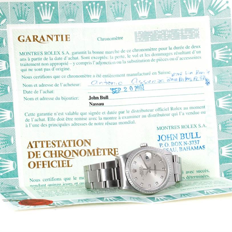 The image shows the Rolex Datejust 16220 Men's Stainless Steel Silver Dial 16220 Men's Stainless Steel Silver Dial watch lying flat on its official warranty certificate from an overhead angle.