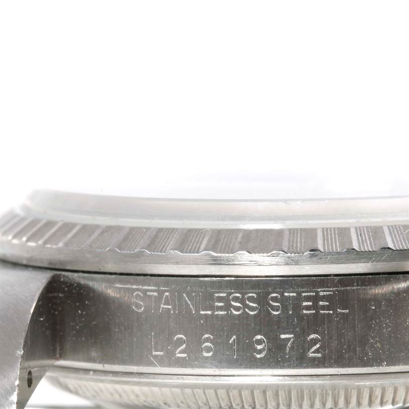 This is a close-up view of the side of a Rolex Datejust 16220 Men's Stainless Steel Beige Dial 16220 Men's Stainless Steel Beige Dial, showing the serial number and part of the bezel.
