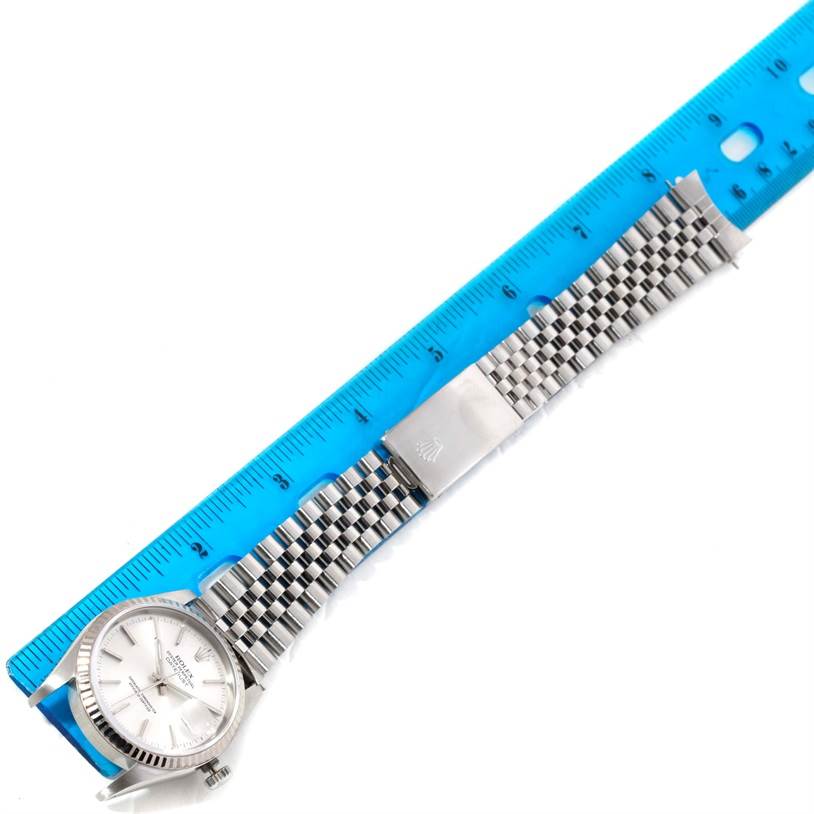 The image shows a full view of the Rolex Datejust 16234 Men's Stainless Steel Silver Dial 16234 Men's Stainless Steel Silver Dial watch laid flat beside a blue ruler, highlighting the bracelet and dial.