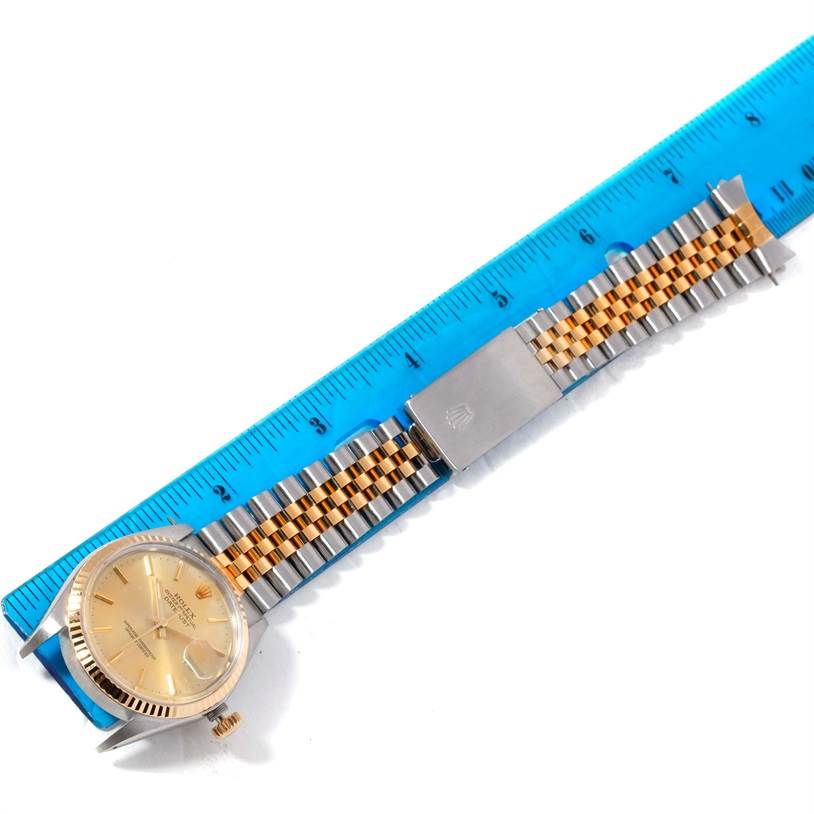 The image displays a Rolex Datejust 16013 Men's Stainless Steel Silver Dial 16013 Men's Stainless Steel Silver Dial watch laid flat with a jubilee bracelet and a blue ruler for scale.